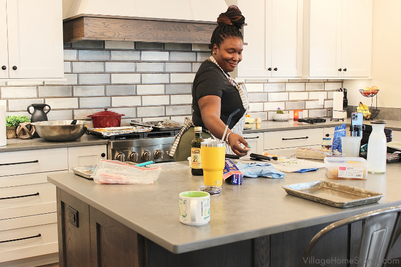 Chef Keys at large kitchen island preparing for brunch in a white cabinet kitchen from Village Home Stores